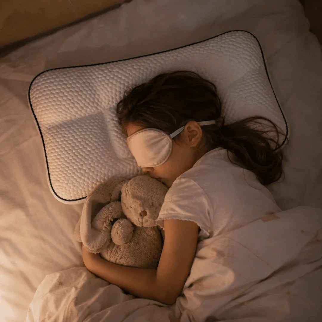 Child asleep on the pillow with a teddy bear