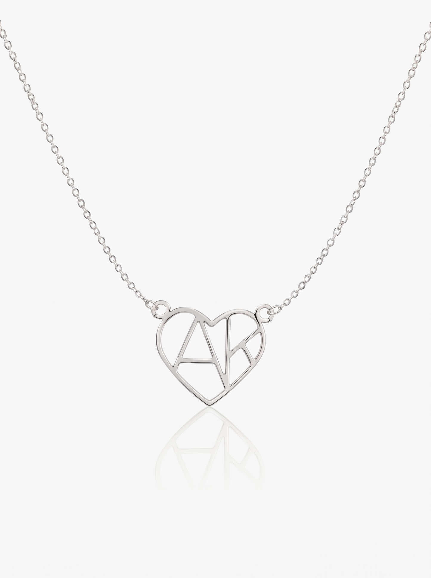 Silver heart initial necklace on white background