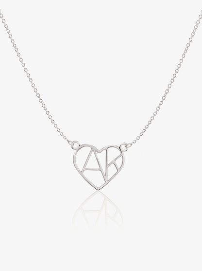 Silver heart initial necklace on white background