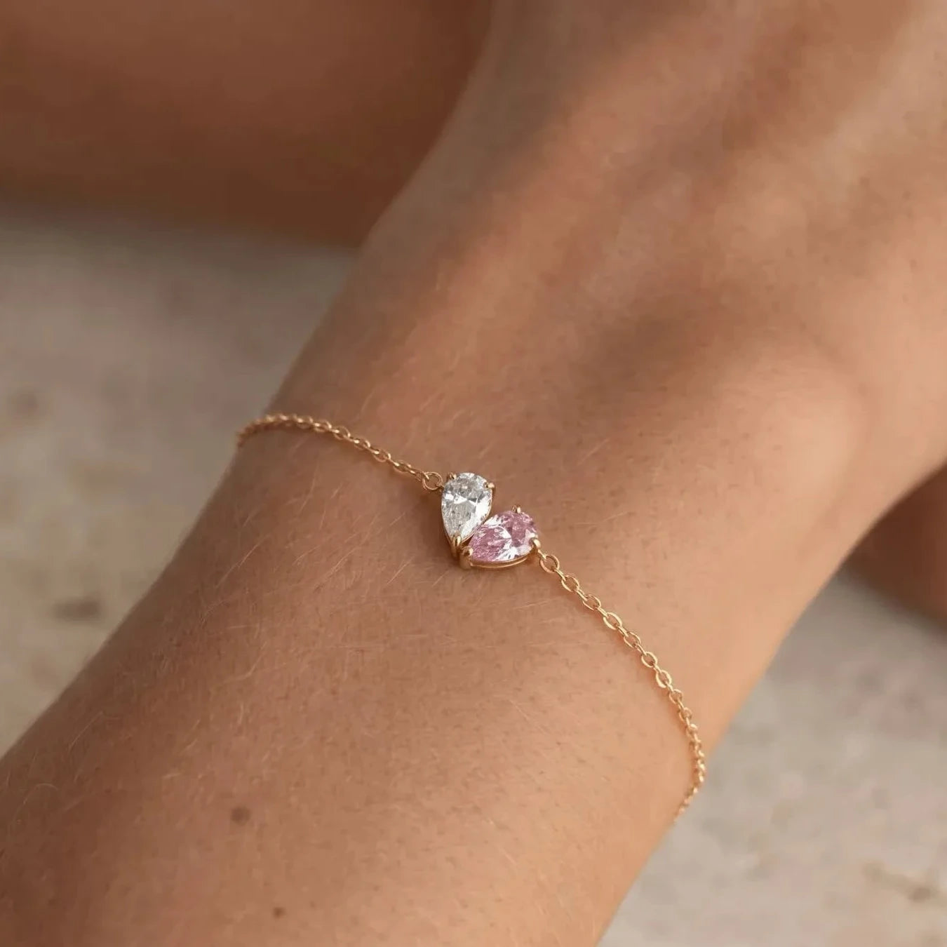 Gold Lori Bracelet worn on wrist, white and pink birthstones