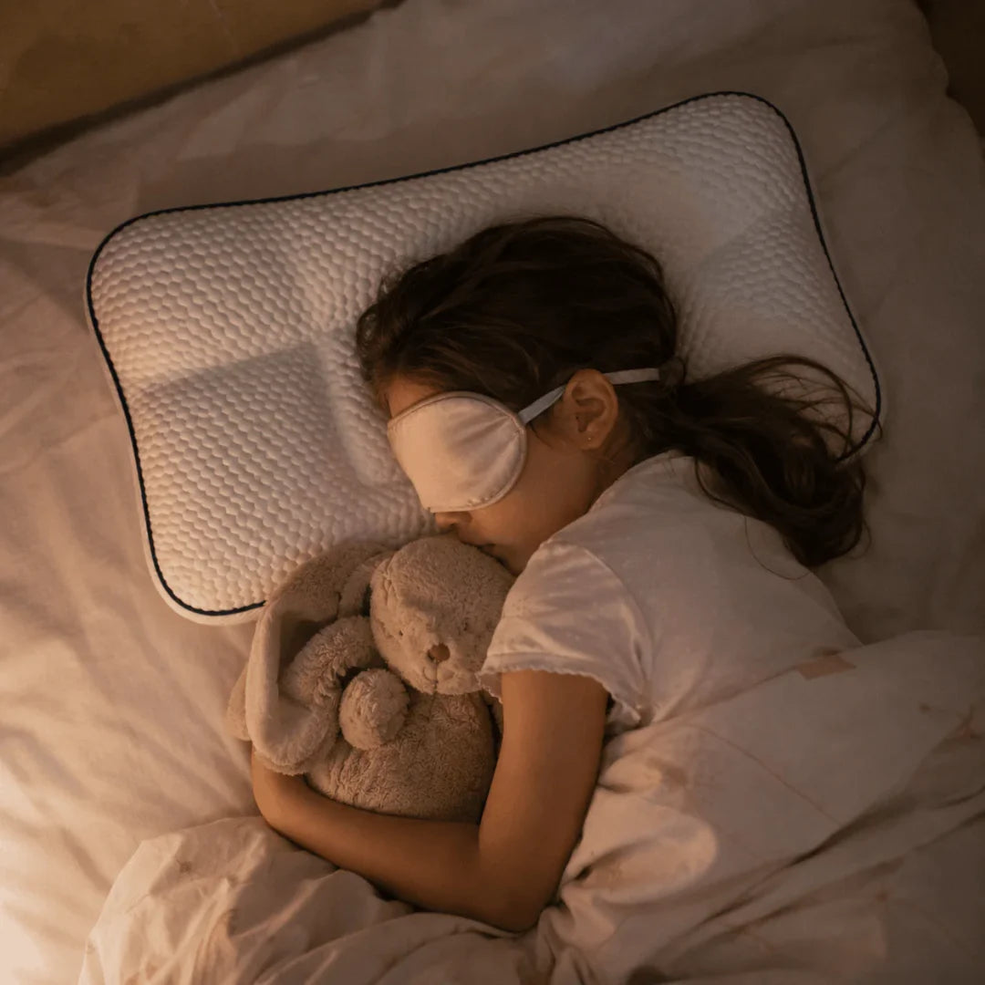 A child asleep with their stuffed animal on the EVERNEL pillow