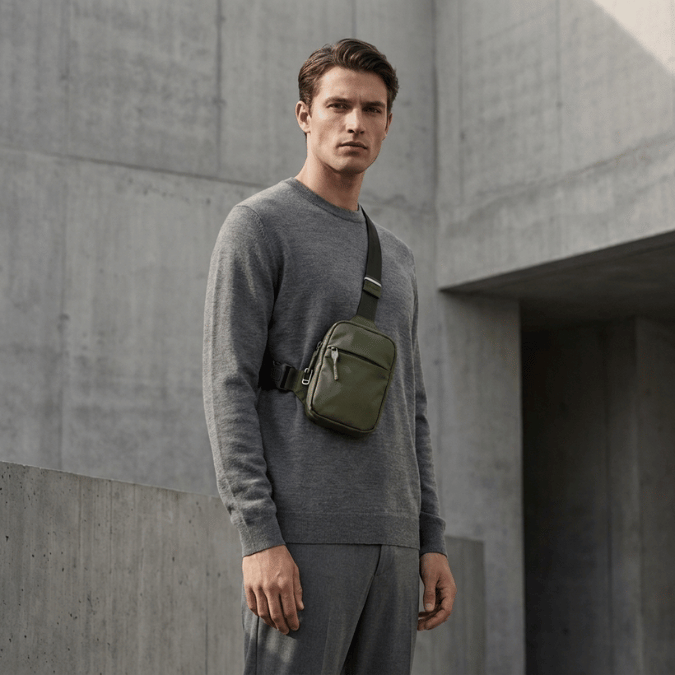 Grey olive sling bag worn close to the body